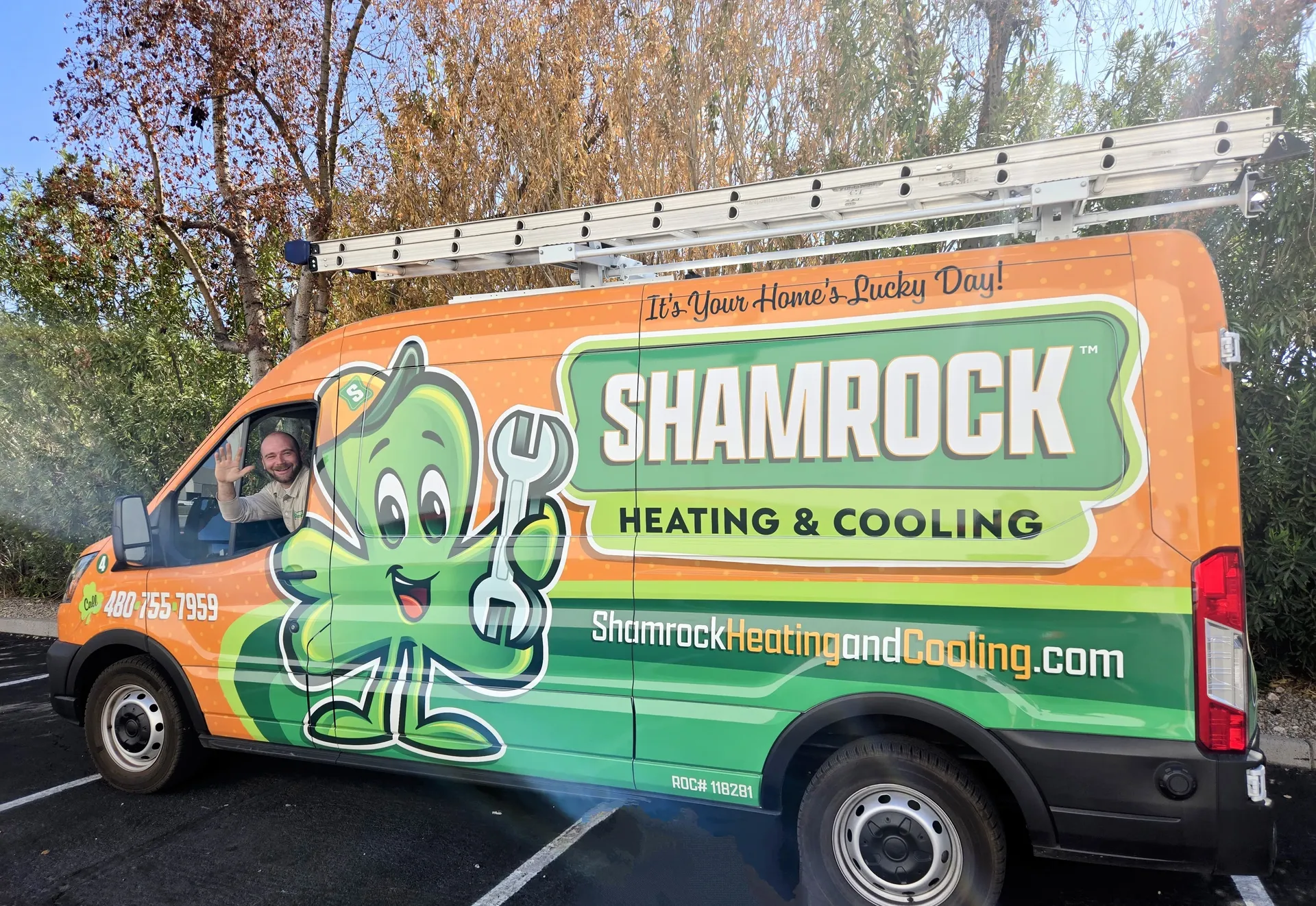 Shamrock HVAC Service Fan with a Shamrock Tech Waving from the Driver's Side Window
