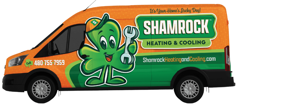 Shamrock Heating and Cooling service van featuring a cheerful shamrock mascot holding a wrench, promoting HVAC solutions and contact information.